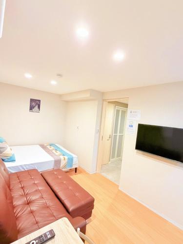 a living room with a couch and a flat screen tv at 無料駐車場あり!Usjまで車で8分!天然温泉まで徒歩1分!海遊館 関西空港!西九条駅 大阪駅直通-1A in Osaka