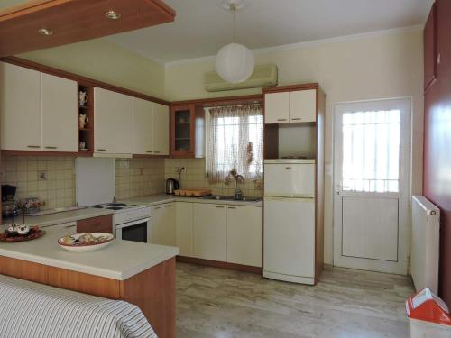 ナフプリオにあるAnastasia Apartmentのキッチン(白いキャビネット、白い冷蔵庫付)