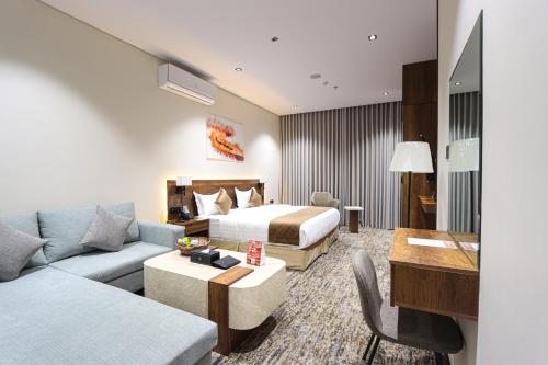 a hotel room with a bed and a couch at فندق تربل ثري in Medina