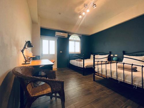 a bedroom with two beds and a desk and a table at Lanyu IGANG Hotel in Lanyu