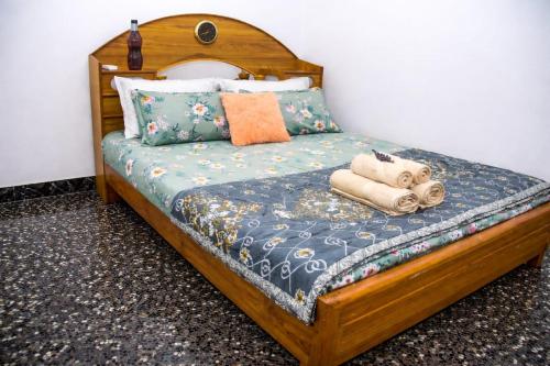a wooden bed with pillows and towels on it at Radiance Crystal in Pondicherry