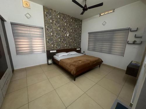 a bedroom with a bed and a ceiling fan at Niramaya Heritage Homestay in Kottayam