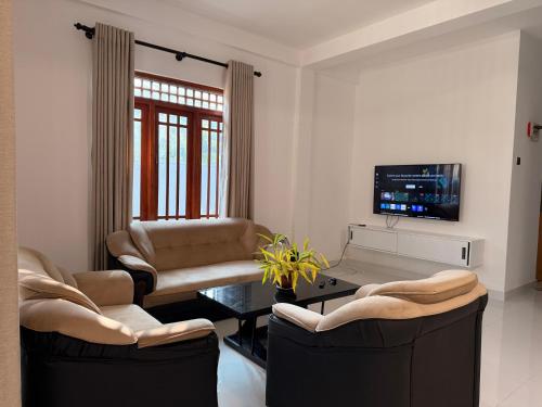 a living room with two chairs and a tv at Rolling Hills Retreat in Katugastota