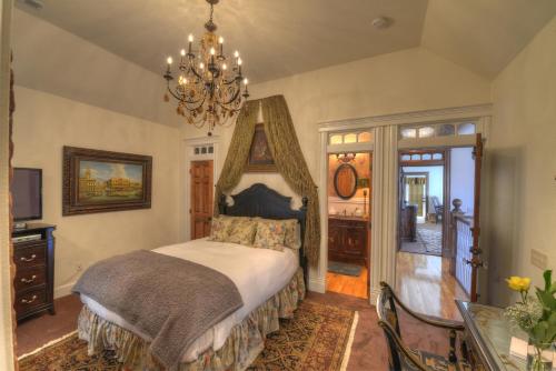 a bedroom with a bed and a chandelier at The Victoria Bed & Breakfast in Bentonville