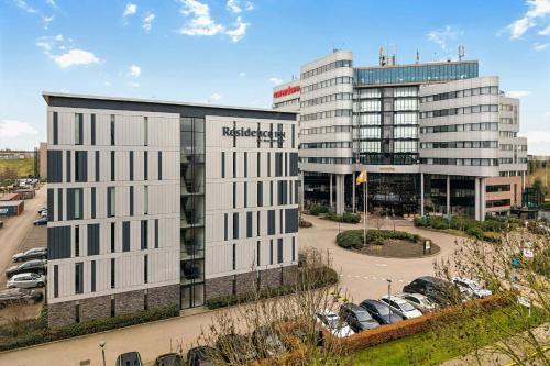 an office building in front of a parking lot at Residence Inn by Marriott Amsterdam Schiphol Airport in Badhoevedorp