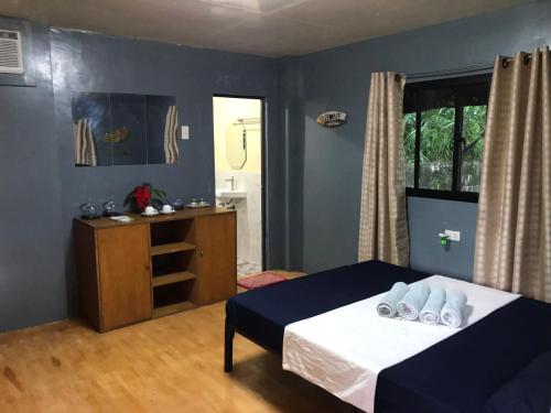 a bedroom with a bed and a cabinet and a window at Hidden Paraiso Resort in Puerto Galera