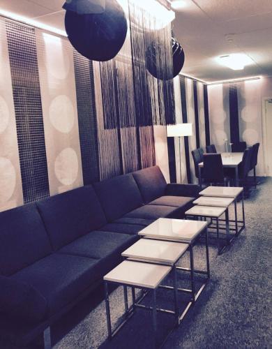 a living room with a couch and tables and chairs at STF Hostel Lärbro/Grannen in Lärbro