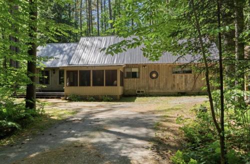 a house with a metal roof and a yard at STARGAZER SHORES LIMIT 8 villa in Bridgton