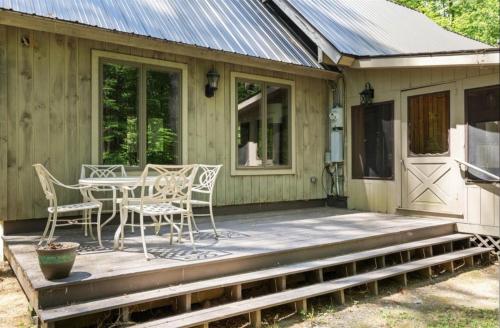 a wooden porch with a table and chairs on it at STARGAZER SHORES LIMIT 8 villa in Bridgton