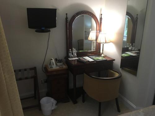a hotel room with a desk and a mirror at Mansfield House Hotel in Hawick