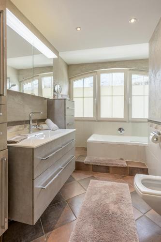 a bathroom with a sink and a tub and a toilet at Hotel Jägerhof Mayrhofen in Mayrhofen