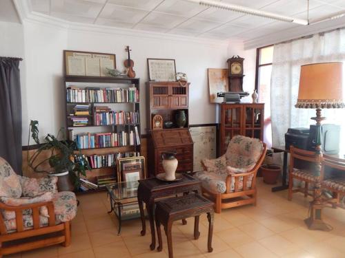 a living room with chairs and a table and book shelves at Residencia Santiago Mallorca in Cala Figuera