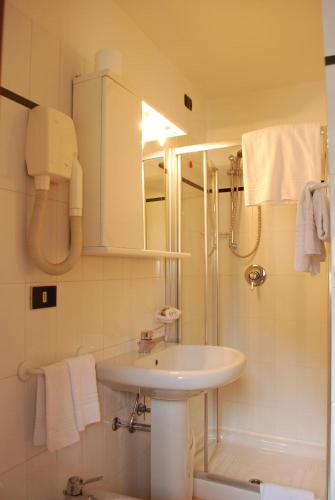 a white bathroom with a sink and a shower at Hotel Pineta in Ponte di Legno