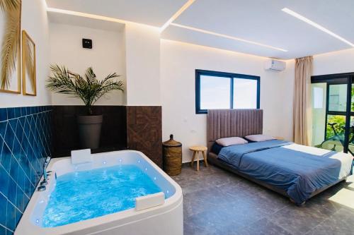 a bedroom with a bed and a bath tub at Villa de luxe piscine chauffée & Jacuzzi & Petit déjeuner in Fez