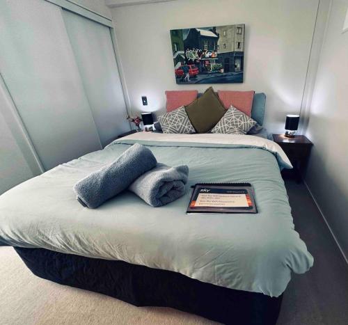 a bedroom with a bed with a tablet on it at Urba Residences in Auckland