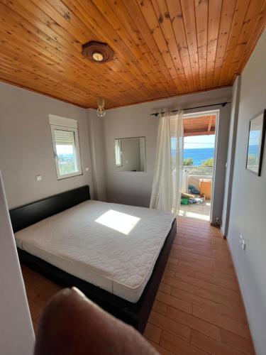 a bedroom with a bed with a wooden ceiling at STUDIO WITH SEA VIEW - KYPARISSIA beach in Kyparissia