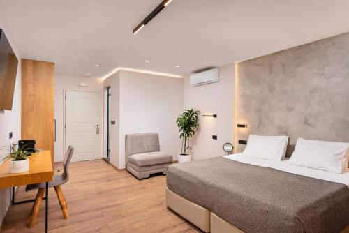 a bedroom with a bed and a desk and a chair at Morfeas Hotel in Chania