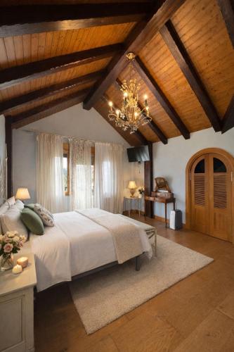 a bedroom with a large bed and a chandelier at Casa Santiago in Argoños