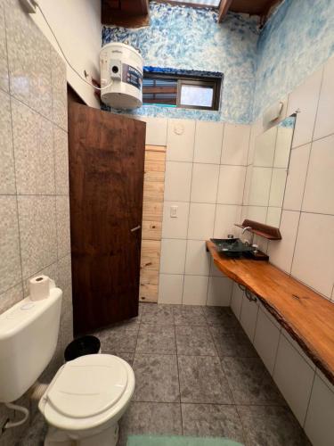 a bathroom with a toilet and a sink at L0st & Found House - Casa Bar in Puerto Iguazú