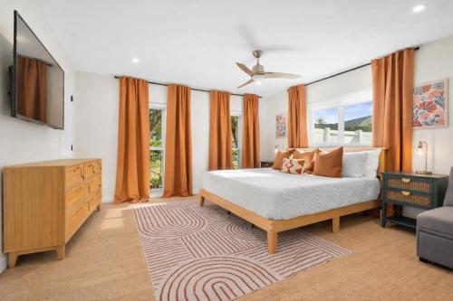 a bedroom with a bed and a dresser and a television at The Mimosa House in Sarasota