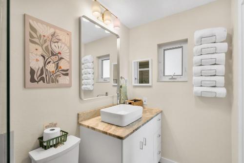 a white bathroom with a sink and a mirror at The Mimosa House in Sarasota