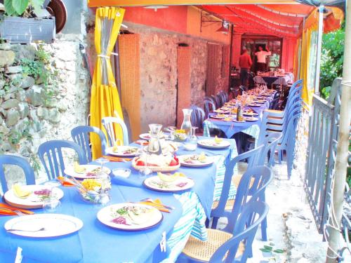 a long table with blue tables and chairs with plates at Il Borgo della Colomba in Fosdinovo