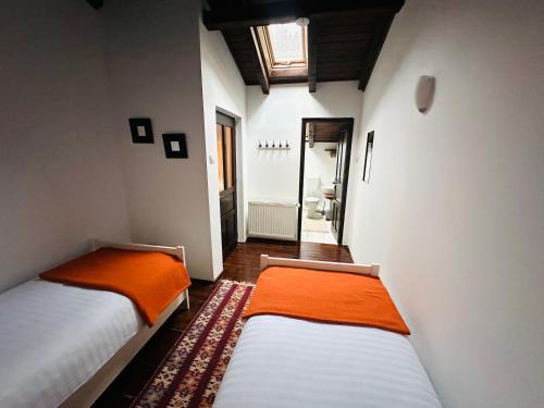two beds in a small room with a hallway at Casa Ema Azuga in Azuga