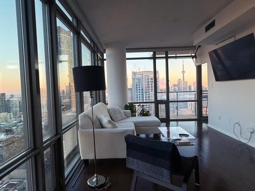 a living room with a white couch and large windows at 44th Floor, Panoramic Views, Bay Corridor Downtown Toronto Condo in Toronto