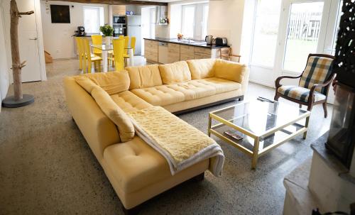 salon z kanapą i stołem w obiekcie Le Semoir w mieście Bény-sur-Mer