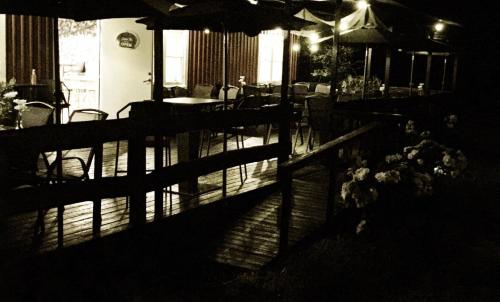 a porch with a fence and tables and chairs at STF Hostel Lärbro/Grannen in Lärbro