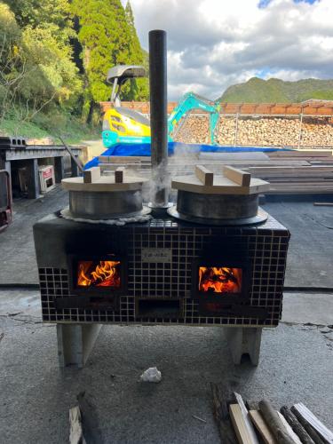an outdoor oven with fire inside of it at Ryuo Field in Kikuchi