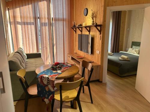 a living room with a table and a room with a couch at Красник Хілс in Krasnik
