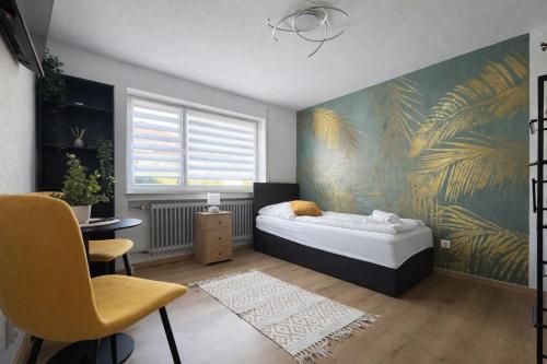 a bedroom with a bed and a wall with a mural at Deluxe Studio Bella in Backnang