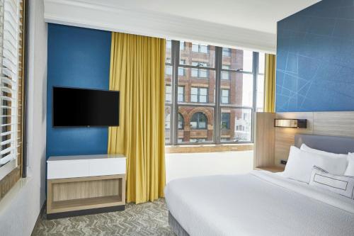 a hotel room with a bed and a television at SpringHill Suites Memphis Downtown in Memphis