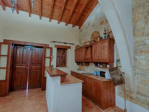 a kitchen with wooden cabinets and a counter top at Komi Lofou House by TrulyCyprus in Lofou