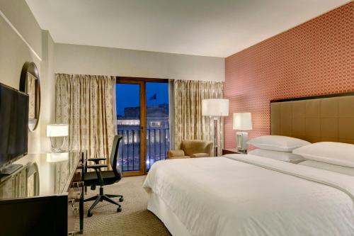 a hotel room with a large bed and a balcony at Sheraton Lima Historic Center in Lima
