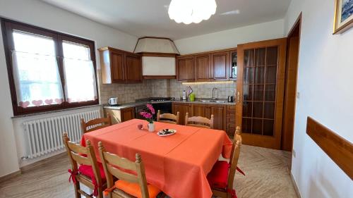 a kitchen with a table with a red table cloth at La Casa di Ekeko in Vivaro