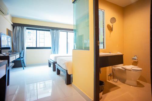 a bedroom with a bed and a sink and a toilet at Neo Hotel Pattaya in Jomtien Beach
