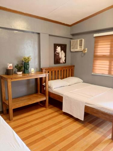 a bedroom with two twin beds and a window at Yana's Place in Donsol