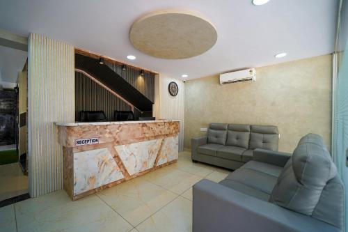 a lobby with a waiting room with a couch and a counter at Open Hotel by Olive - Hilvon Business Hotel in Bangalore