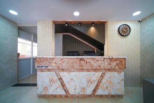 an office with a clock on the wall and a reception desk at Open Hotel by Olive - Hilvon Business Hotel in Bangalore
