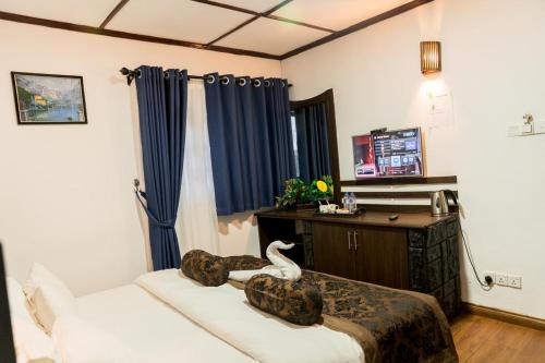 a bedroom with a bed with a swan on it at NAT CITY Hotel in Nuwara Eliya