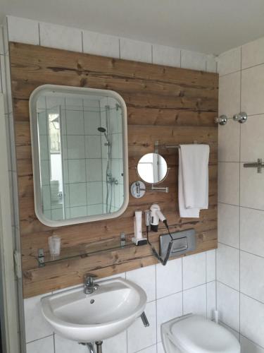 a bathroom with a sink and a mirror at Stadthotel Augsburger Hof in Landsberg am Lech