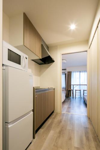 a kitchen with a refrigerator and a dining room at trive meieki nishi 106 最大6名宿泊可 名古屋駅まで1駅 太閤通駅徒歩4分 角部屋 無料駐車場付き in Nagoya