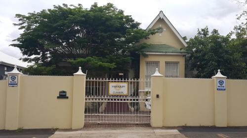a white fence in front of a house at Sommersby Bed & Breakfast in Durban