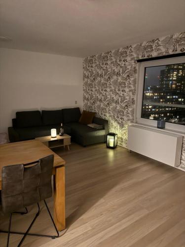 a living room with a couch and a large window at 1 bedroom appartement in the center of Rotterdam in Rotterdam