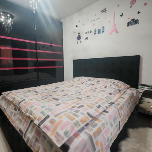 a bedroom with a bed with a comforter on it at Magic Apartments 3 in Miercurea-Ciuc