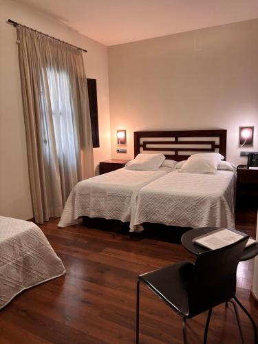 a hotel room with two beds and a chair at Casa del Trigo in Santa Fe