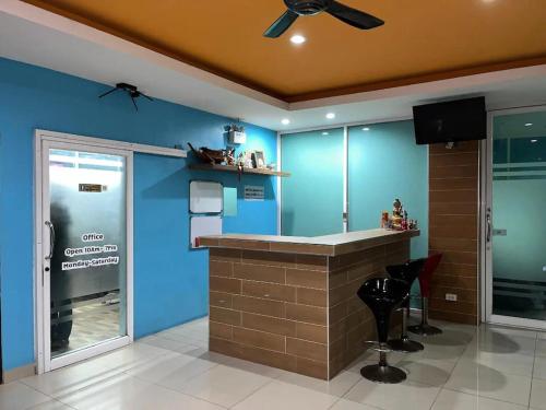 a bar in a room with a blue wall at Illusion Hostel & Club in Pattaya South