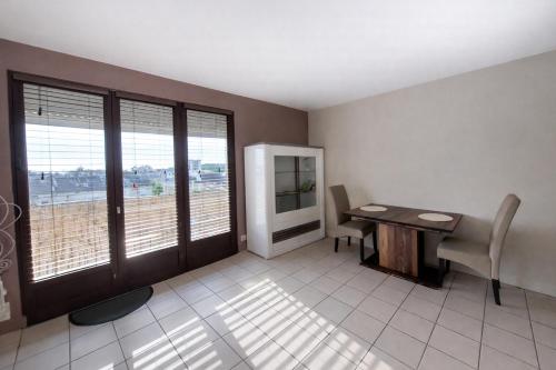a room with a desk and a table and some windows at Le Cosy Gaillard 3 étoiles, magnifique vue sur la ville, parking privé et proche du centre in Brive-la-Gaillarde